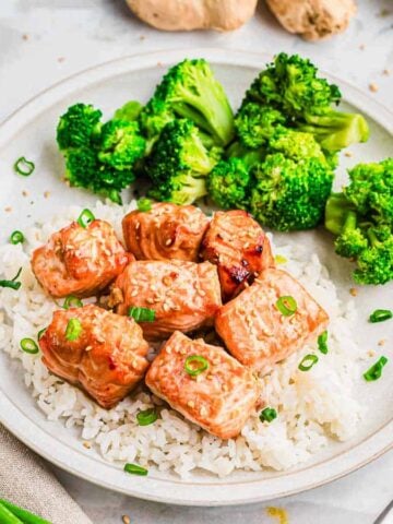 A plate with air fryer salmon bites, rice, broccoli and sauce on it.
