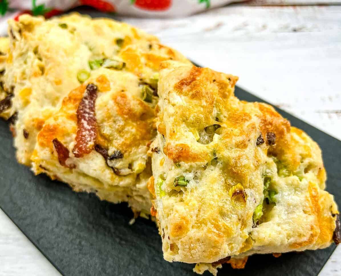 Bacon, Cheddar, Green Onion Scones on a black plate.