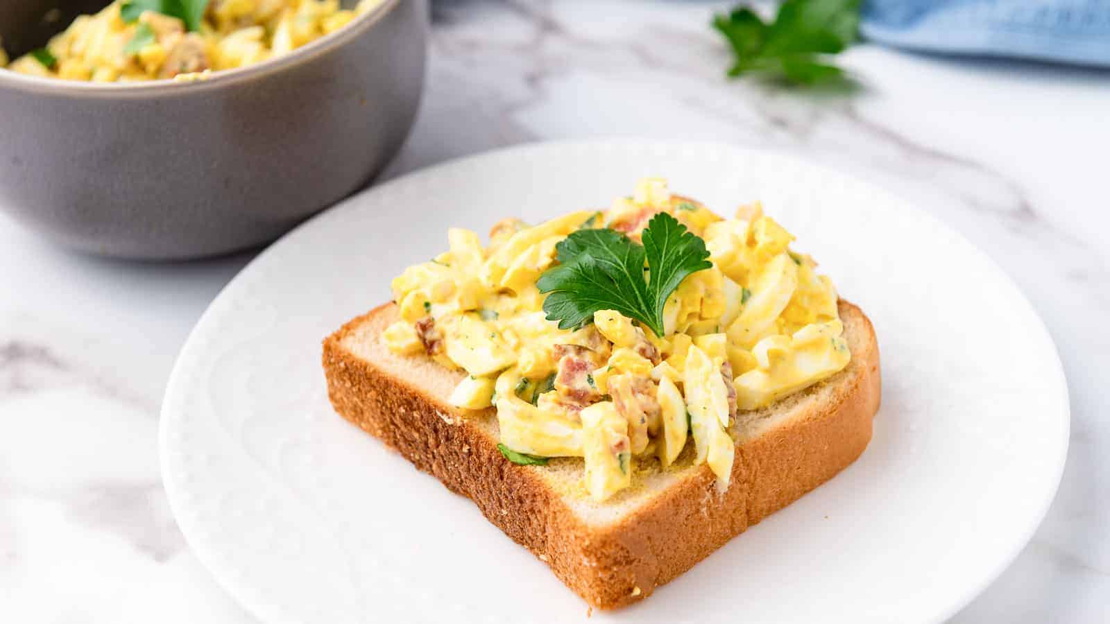 Egg salad on a piece of white bread.