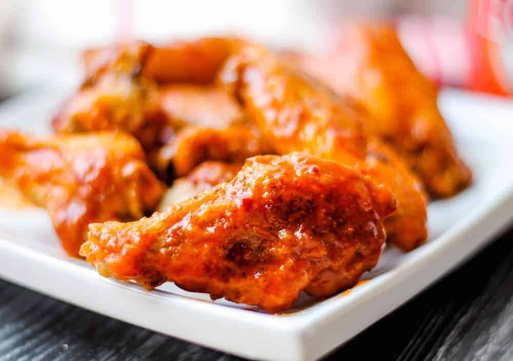 A plate of saucy Oven Baked Chicken Wings.
