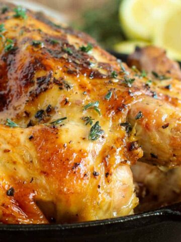 A roasted chicken in a cast iron skillet.