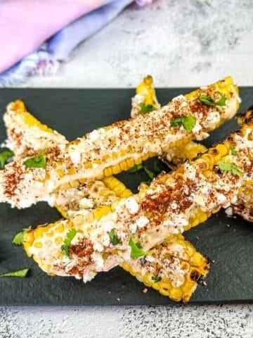 Grilled Elote Corn Ribs on a black platter.