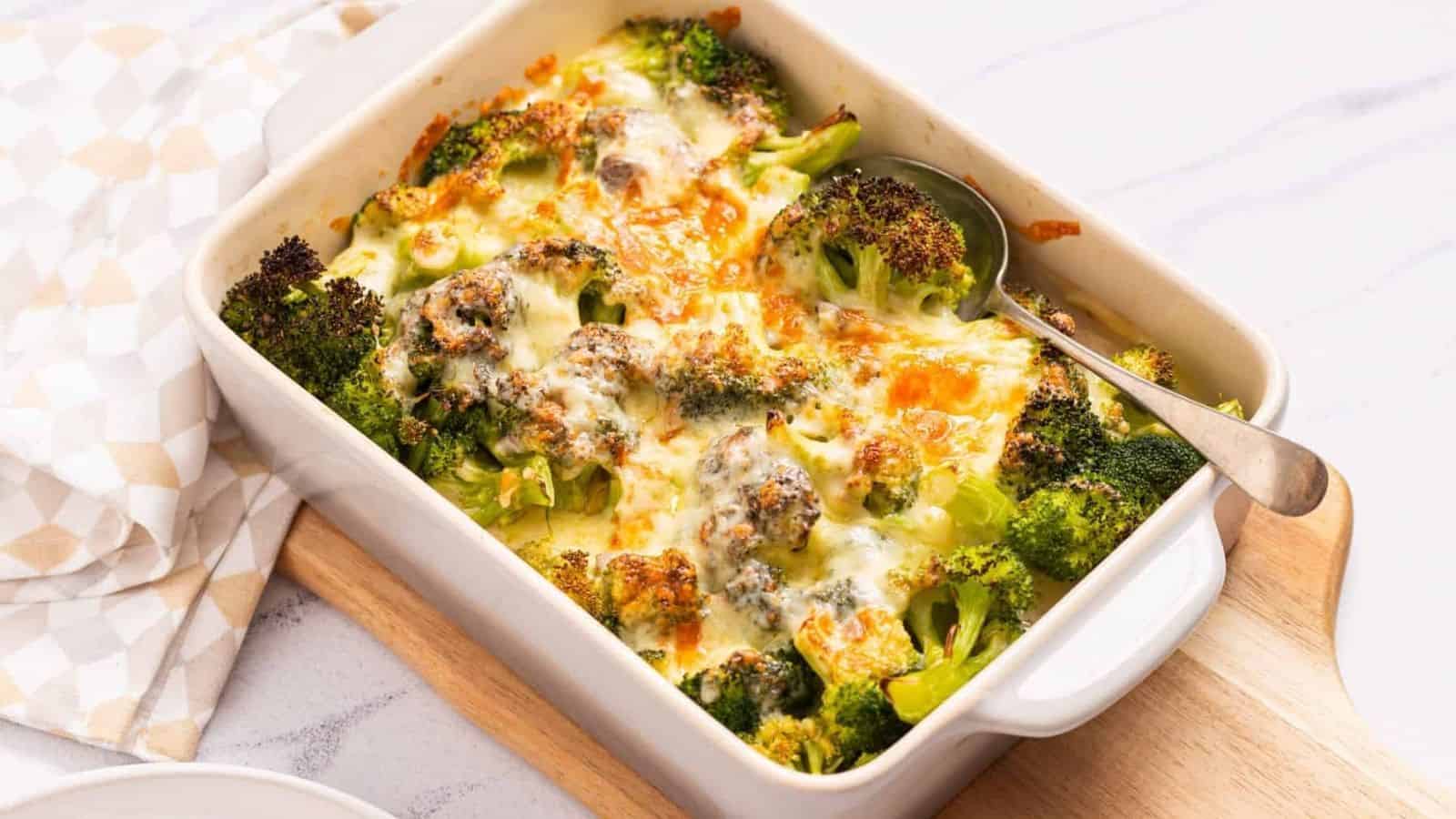 An image of broccoli cheese casserole served on a table with a spoon on the right side.