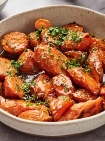 Air fryer glazed carrots in a bowl with parsley.