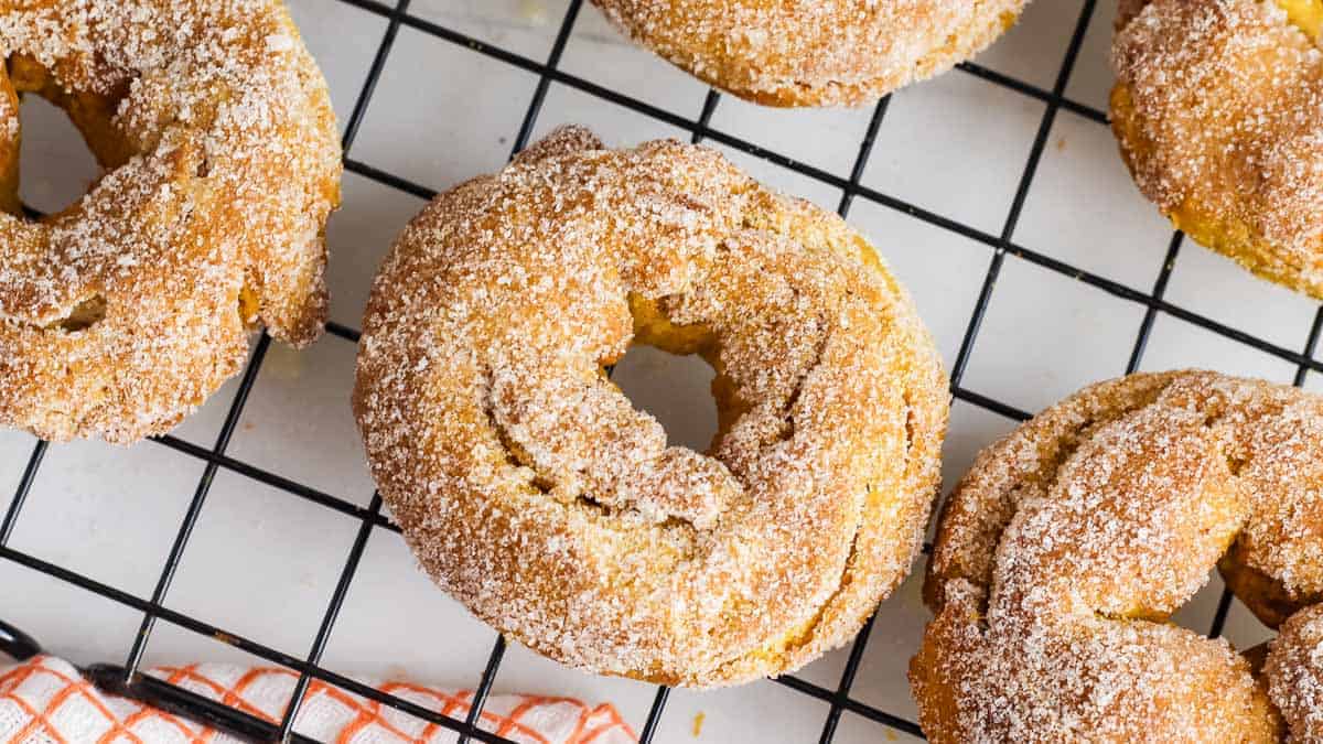 Air Fryer Pumpkin Donuts on a cooling rack.