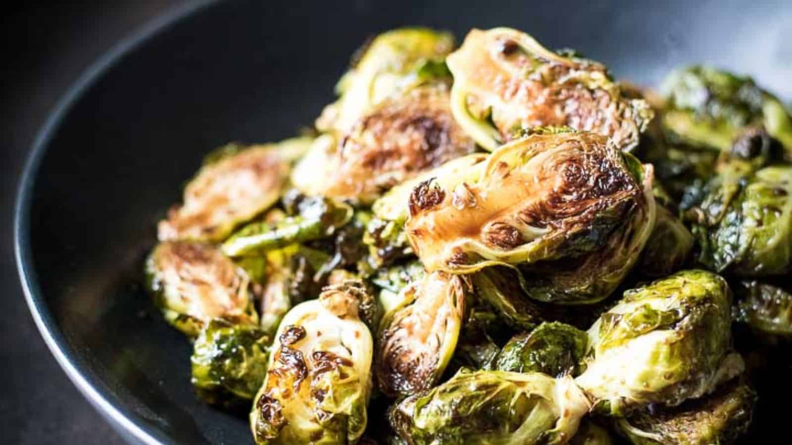 Roasted balsamic glazed brussels sprouts in a black bowl.