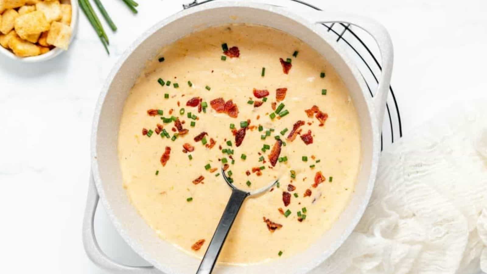 Overhead image of beer cheese soup with a spoon in a bowl.