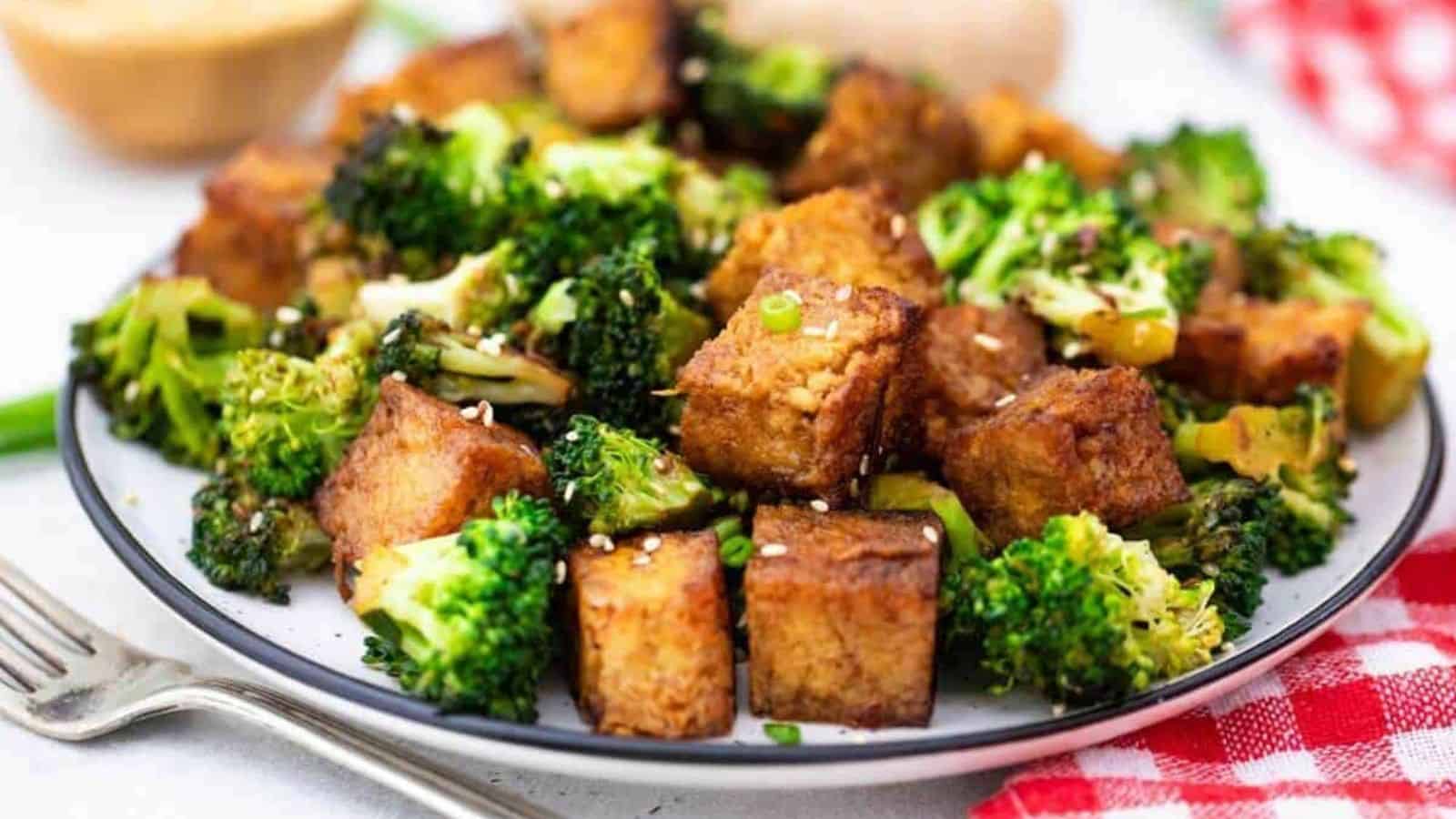 Tofu and broccoli on a plate.