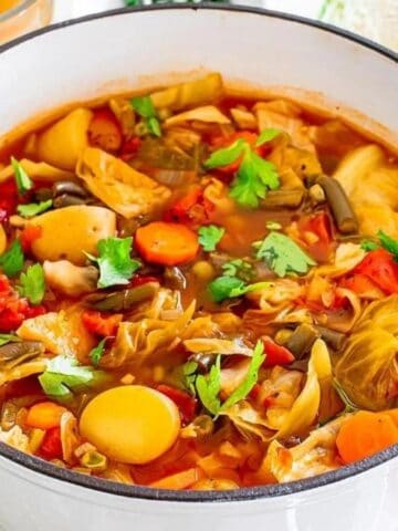 Cabbage vegetable soup in a white pot.
