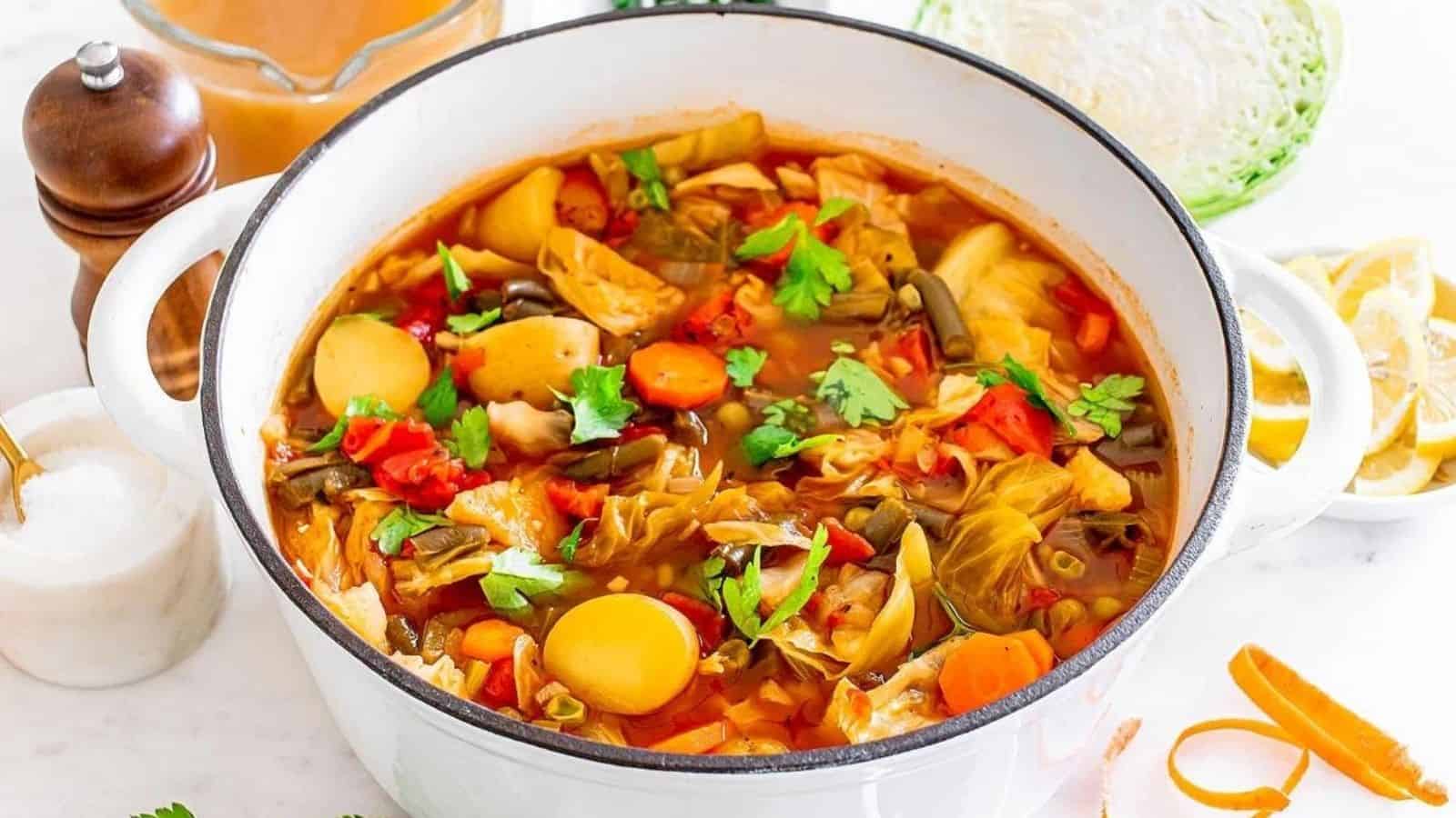 Cabbage vegetable soup in a white pot.