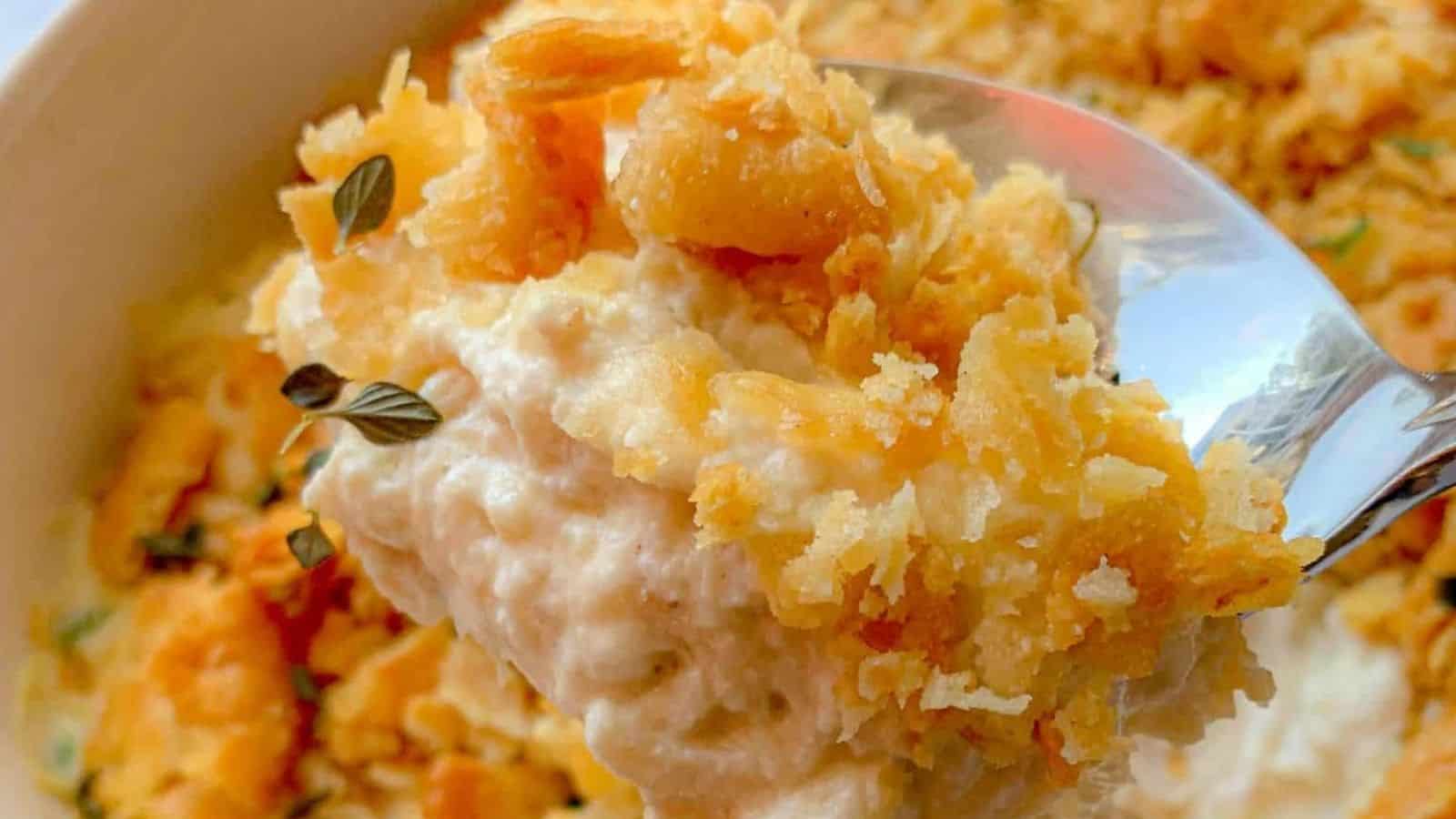 A spoonful of chicken casserole with a Ritz cracker topping.