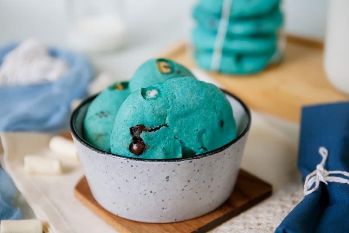 A bowl of blue cookies with decorative eyes on top.