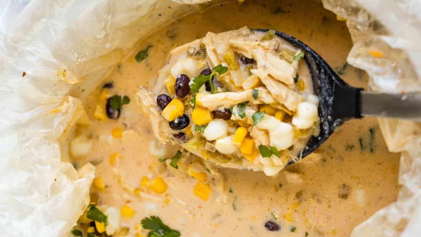 A bowl of mexican chicken chowder with corn and black beans.