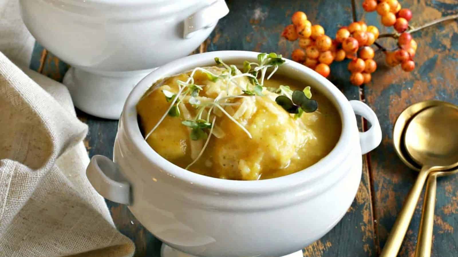 Two bowls of butternut squash soup on a wooden table.