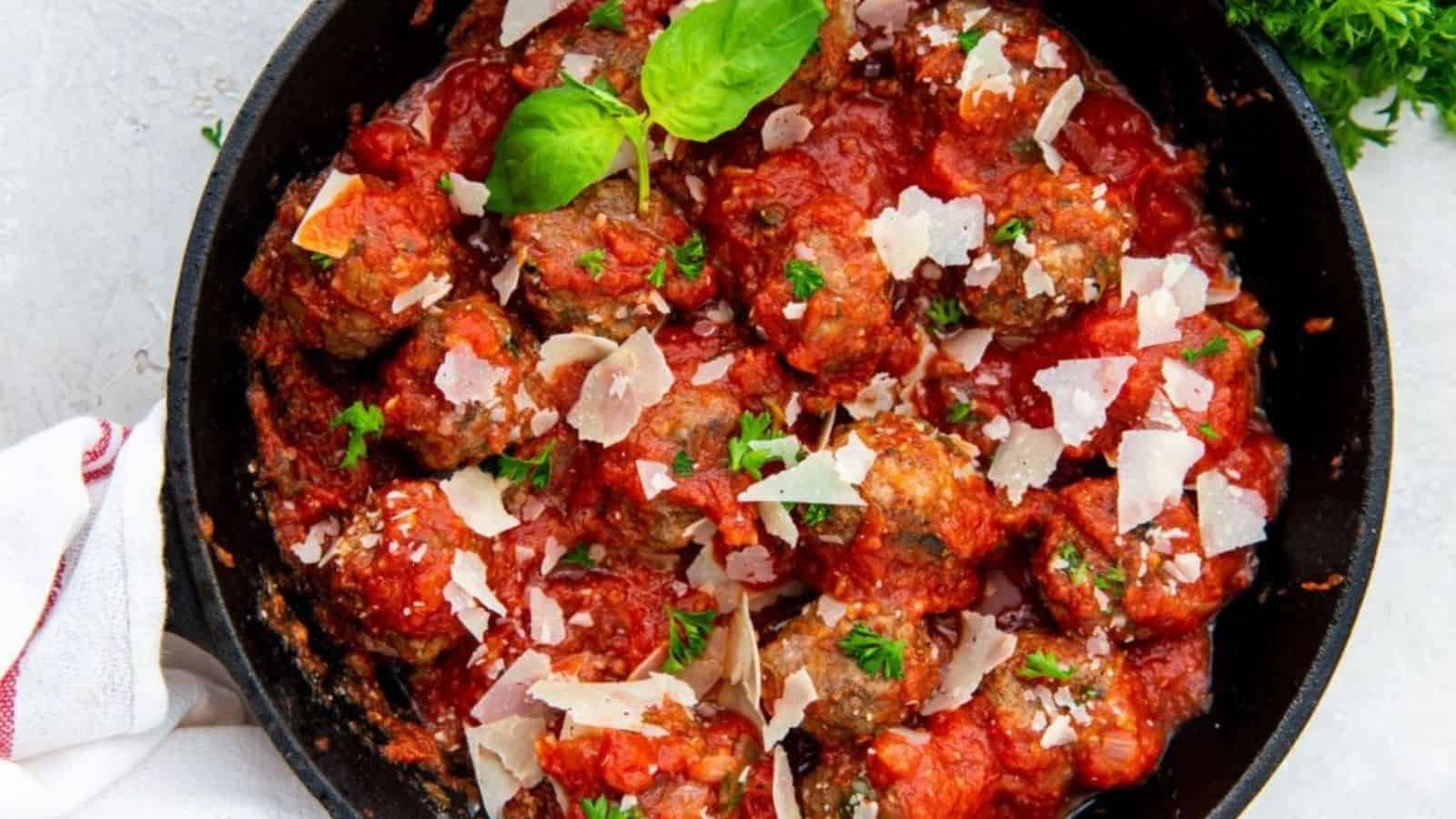 Overhead image of cast iron skillet meaballs in a pan.