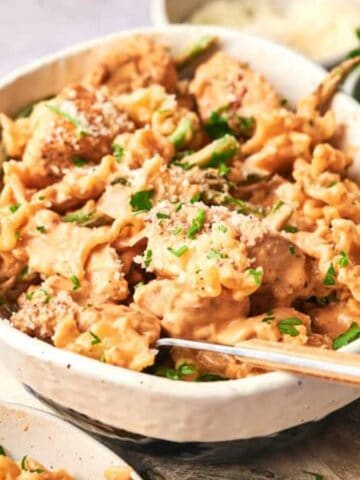 A bowl of Easy Spicy Chicken Chipotle Pasta in a wooden board.