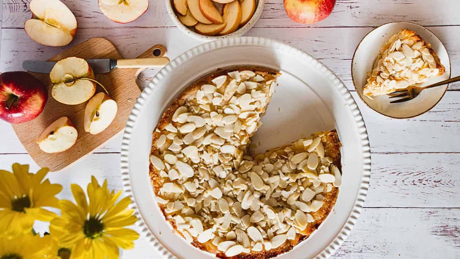 A plate of apple pie with a slice taken out of it.