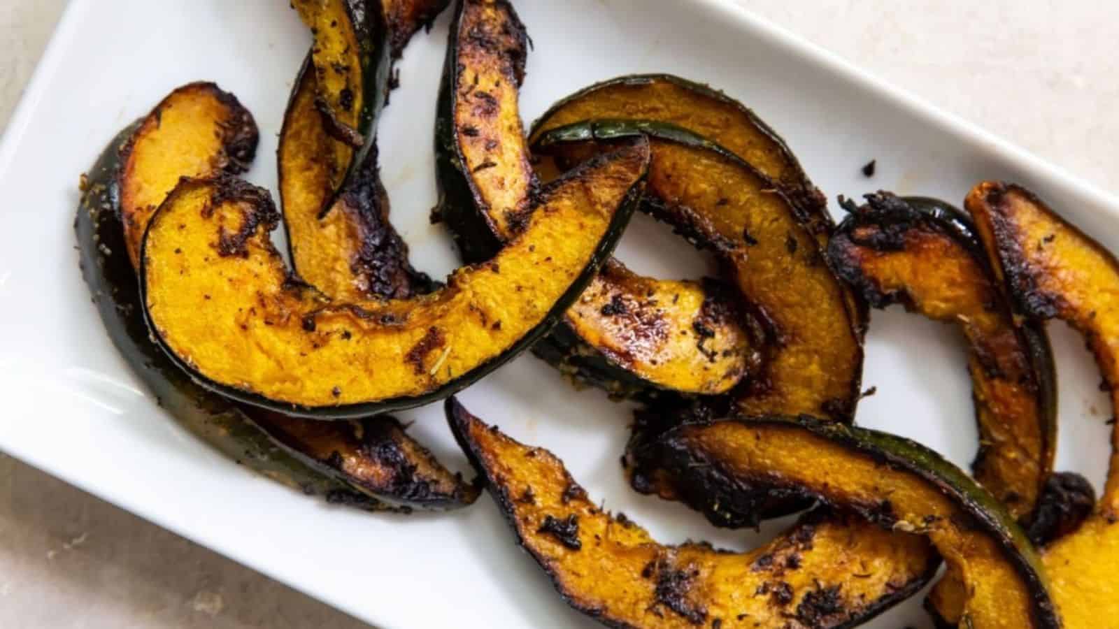 Overhead image of grilled blackstone acorn squash in a plate.