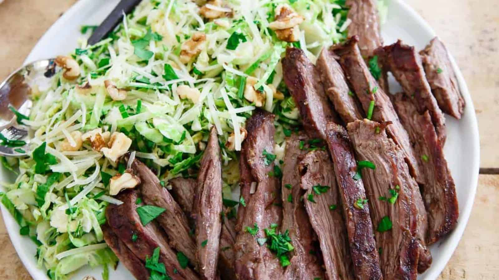 A close-up of a plate of Grilled Skirt Steak with Brussels Sprouts Salad.