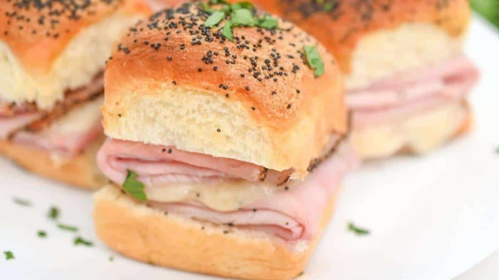 Ham and cheese sliders on a plate.