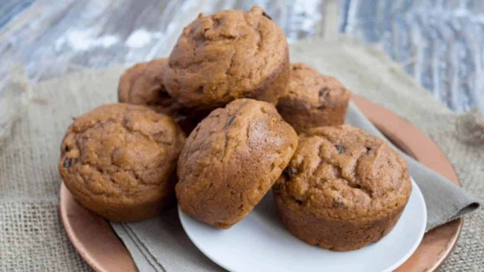 A pile of pumpkin muffins on a white plate.