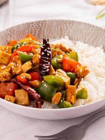 An image of kung pao tofu served in a bowl over rice.