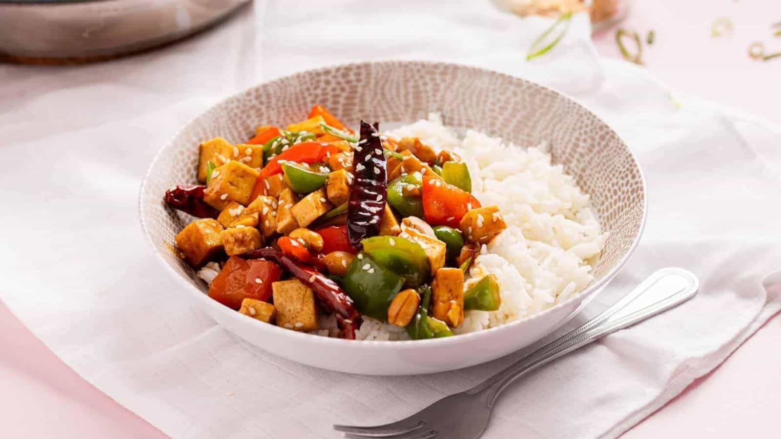 An image of kung pao tofu served in a bowl over rice.