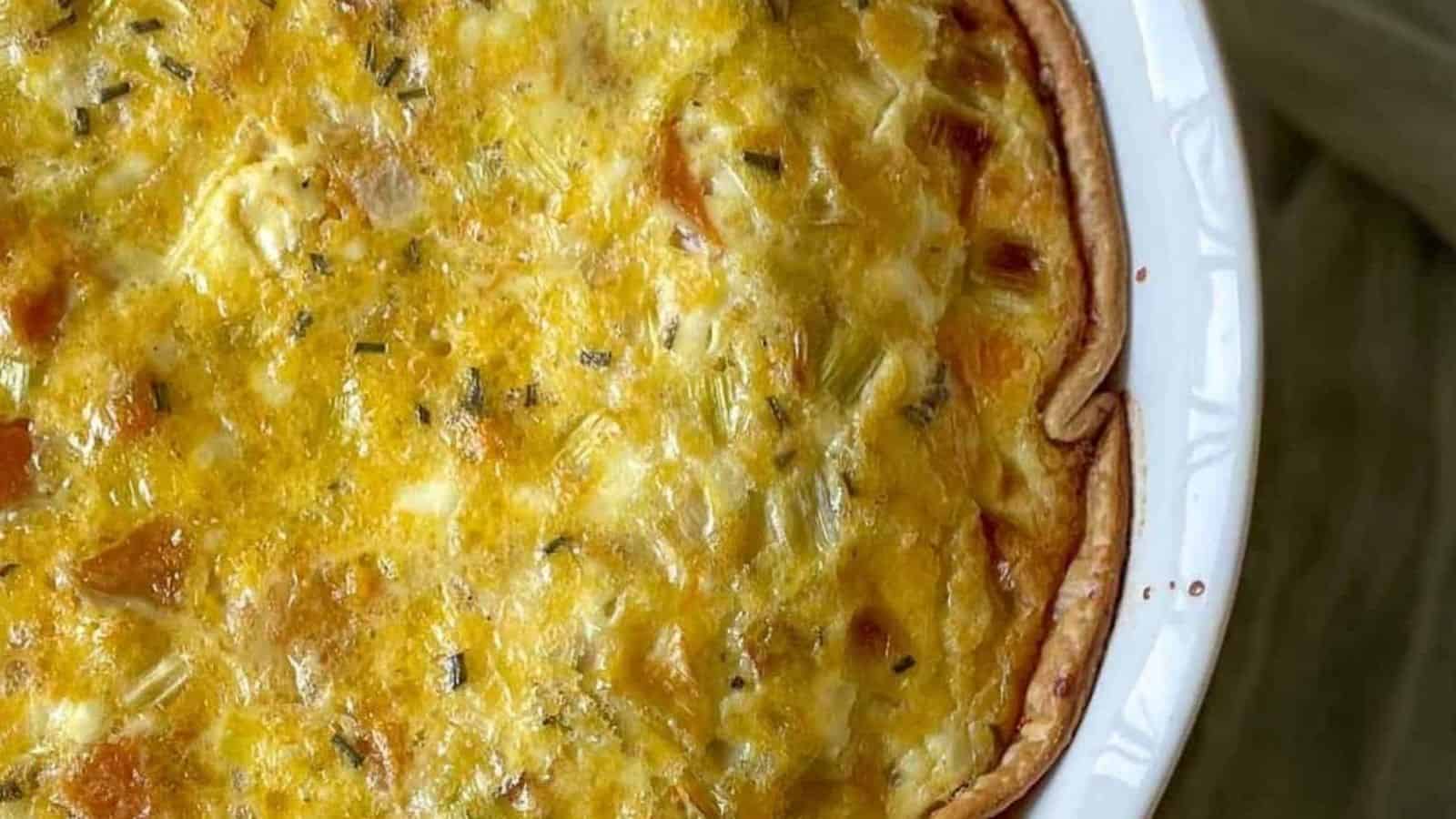 Closeup of leek and squash quiche with a green linen.