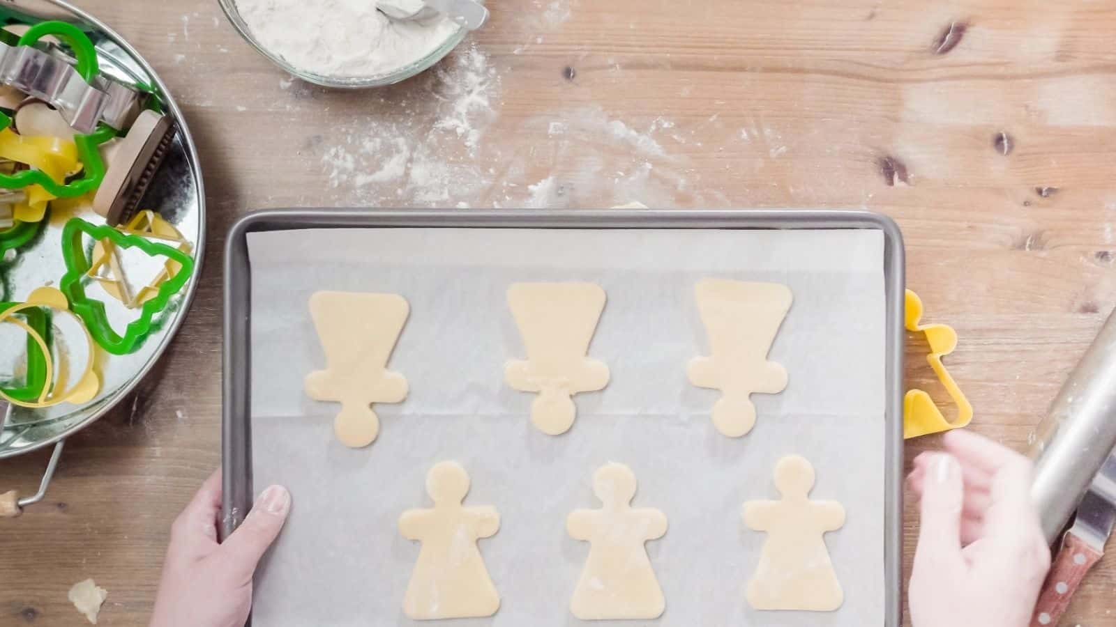 Sugar cookies on top of a sheet pan with parchment paper.