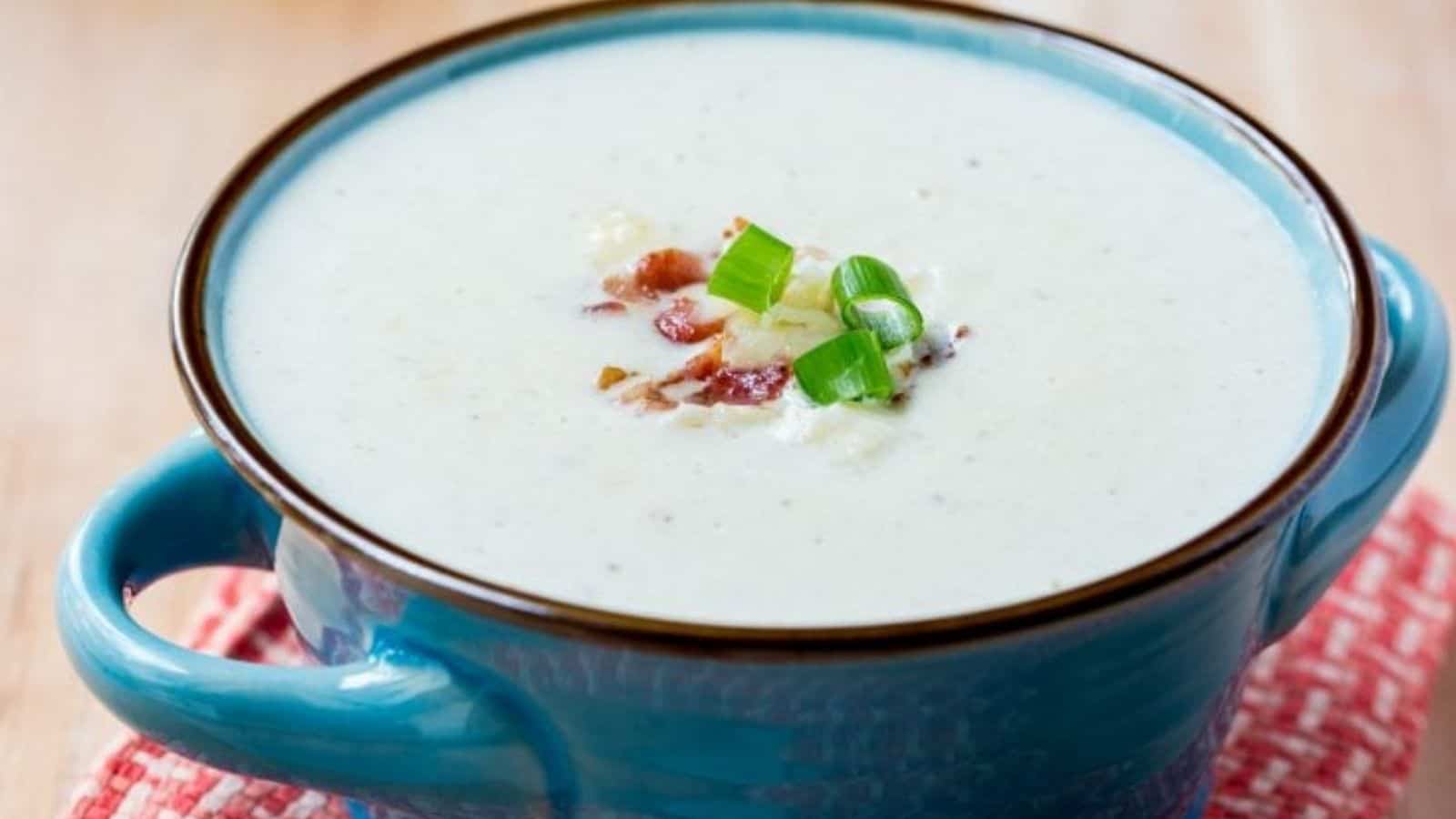 Low carb bacon cheddar cauliflower soup in a blue bowl.