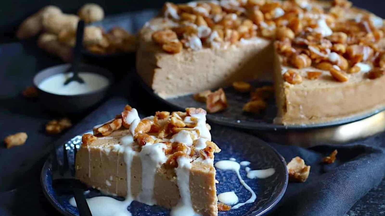 Peanut Butter Cheesecake on a plate with caramelized nuts on top.