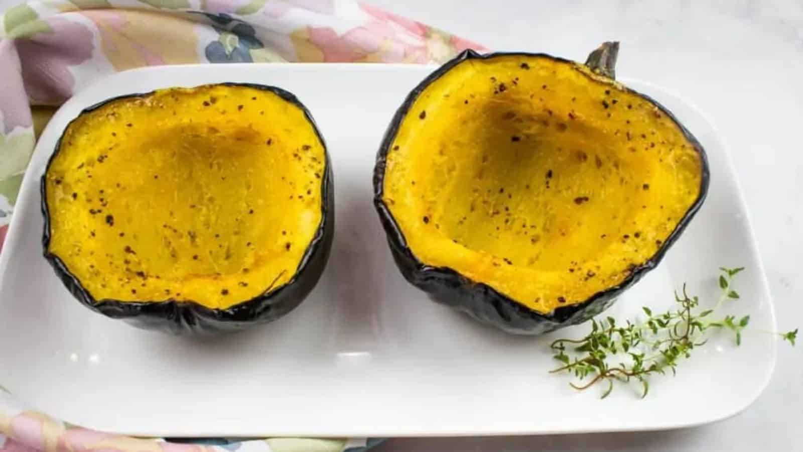 Two pieces of maple roasted acorn squash on a plate.