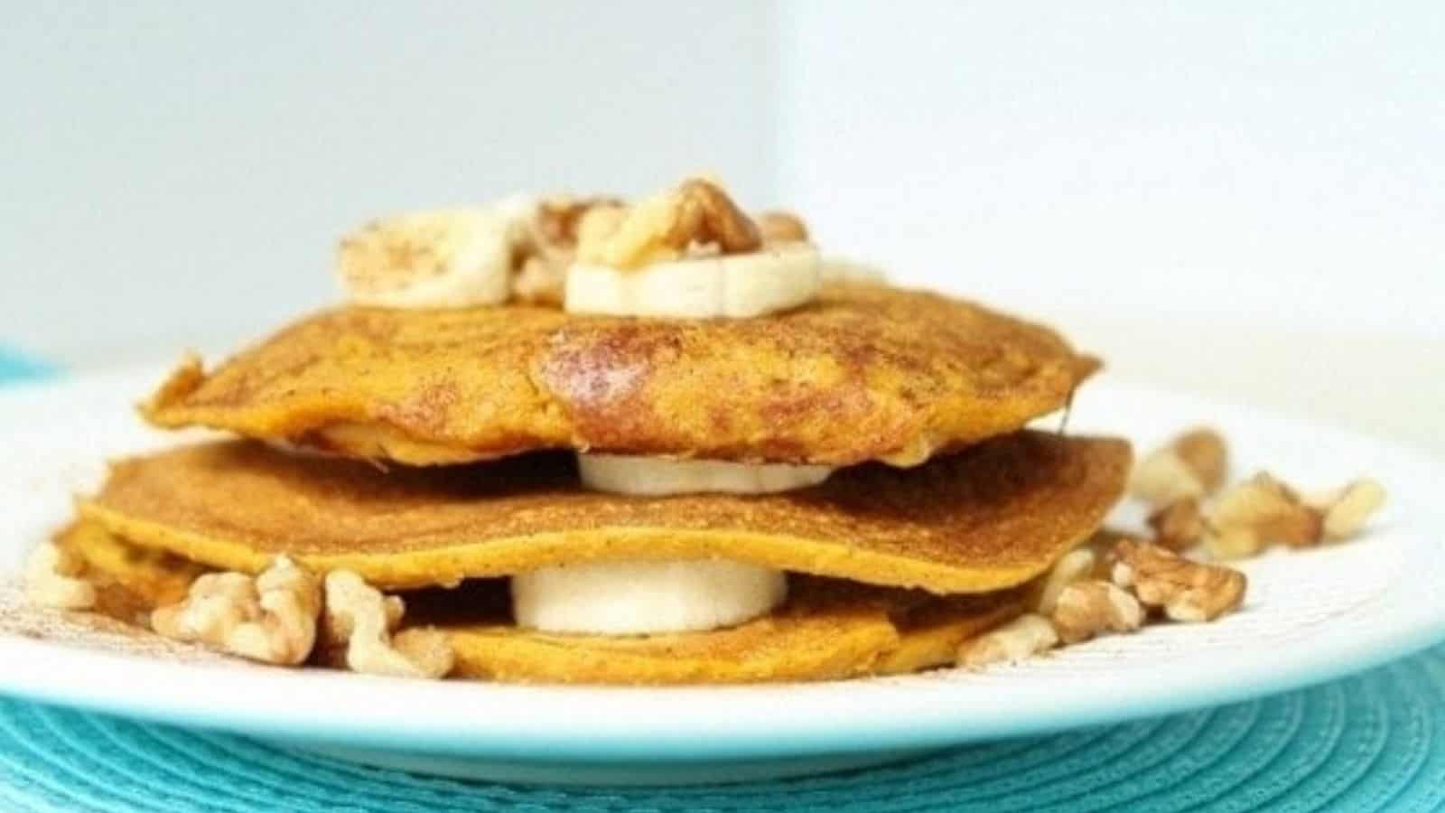 3 layers of oatmeal pumpkin pancakes on a plate.