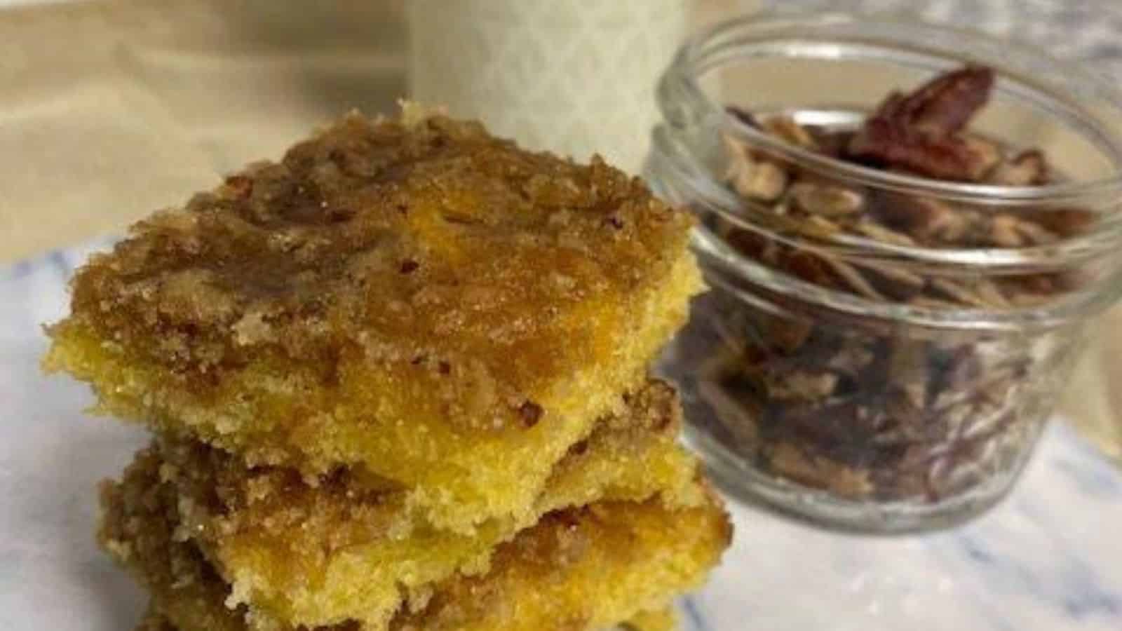 Stack of four pecan cake bars on marble board.