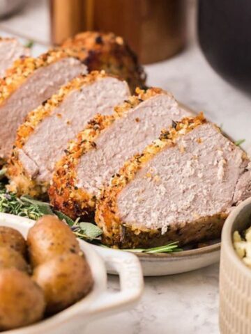 A plate of sliced Parmesan Herb Crusted Pork Tenderloin.