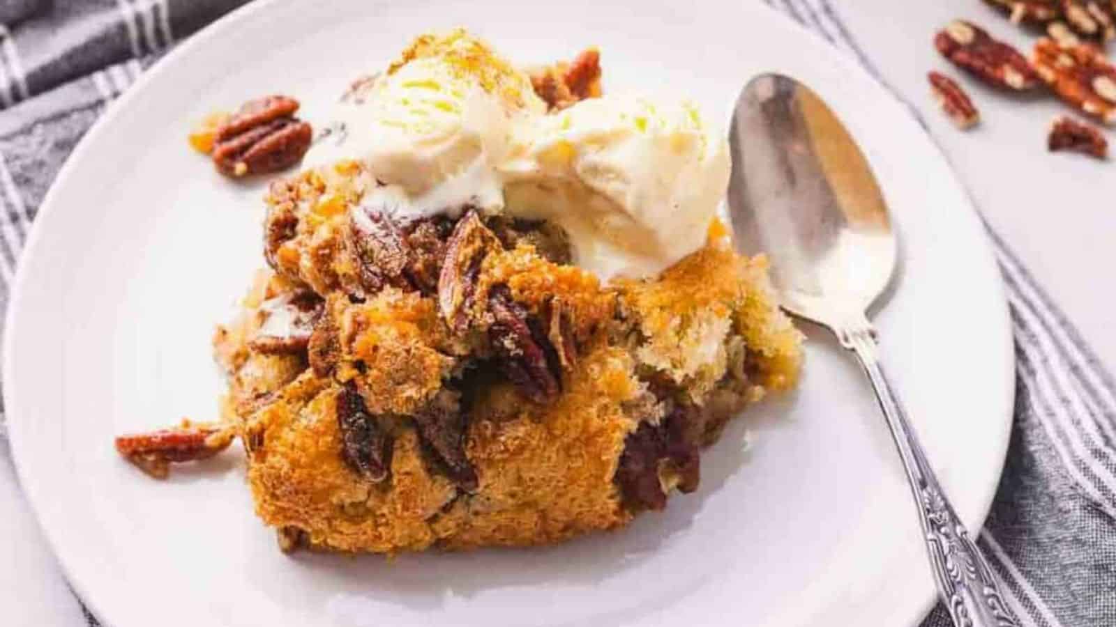 Close-up image of pecan cobbler with a spoon on a plate.