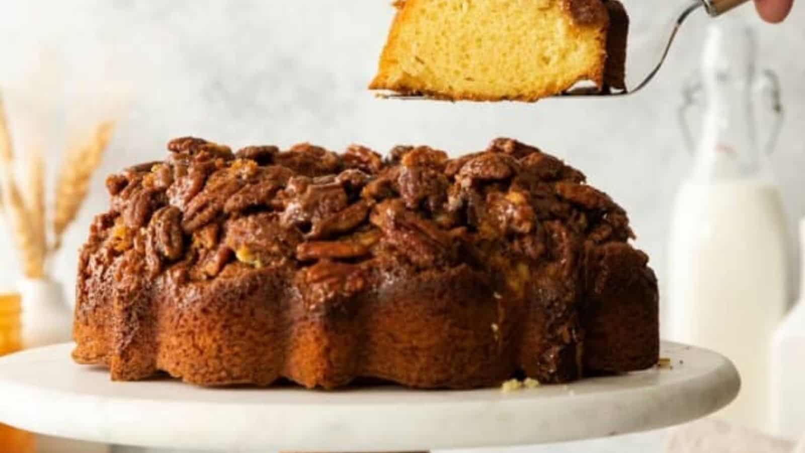 Slice of pecan upside down cake being lifted by a slicer.