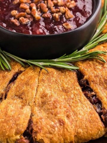 Close-up imagge of piineapple cranberry brie crescent ring with spiked cranbberry sauce.