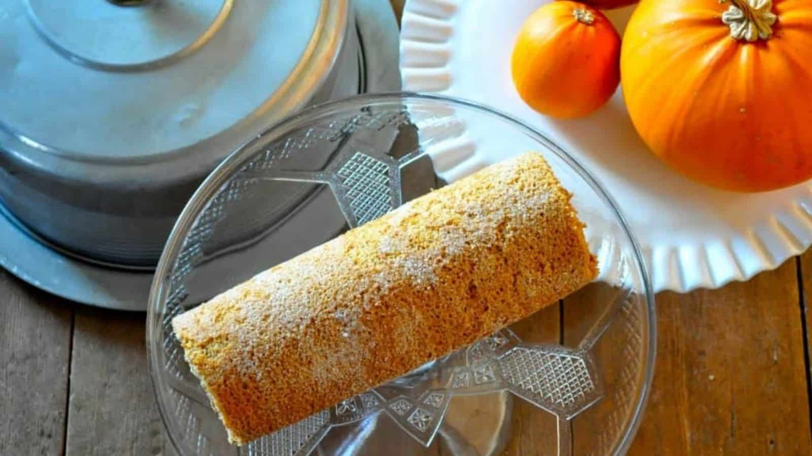 Overhead image of pumpkin spice cake roll on a glass plate.