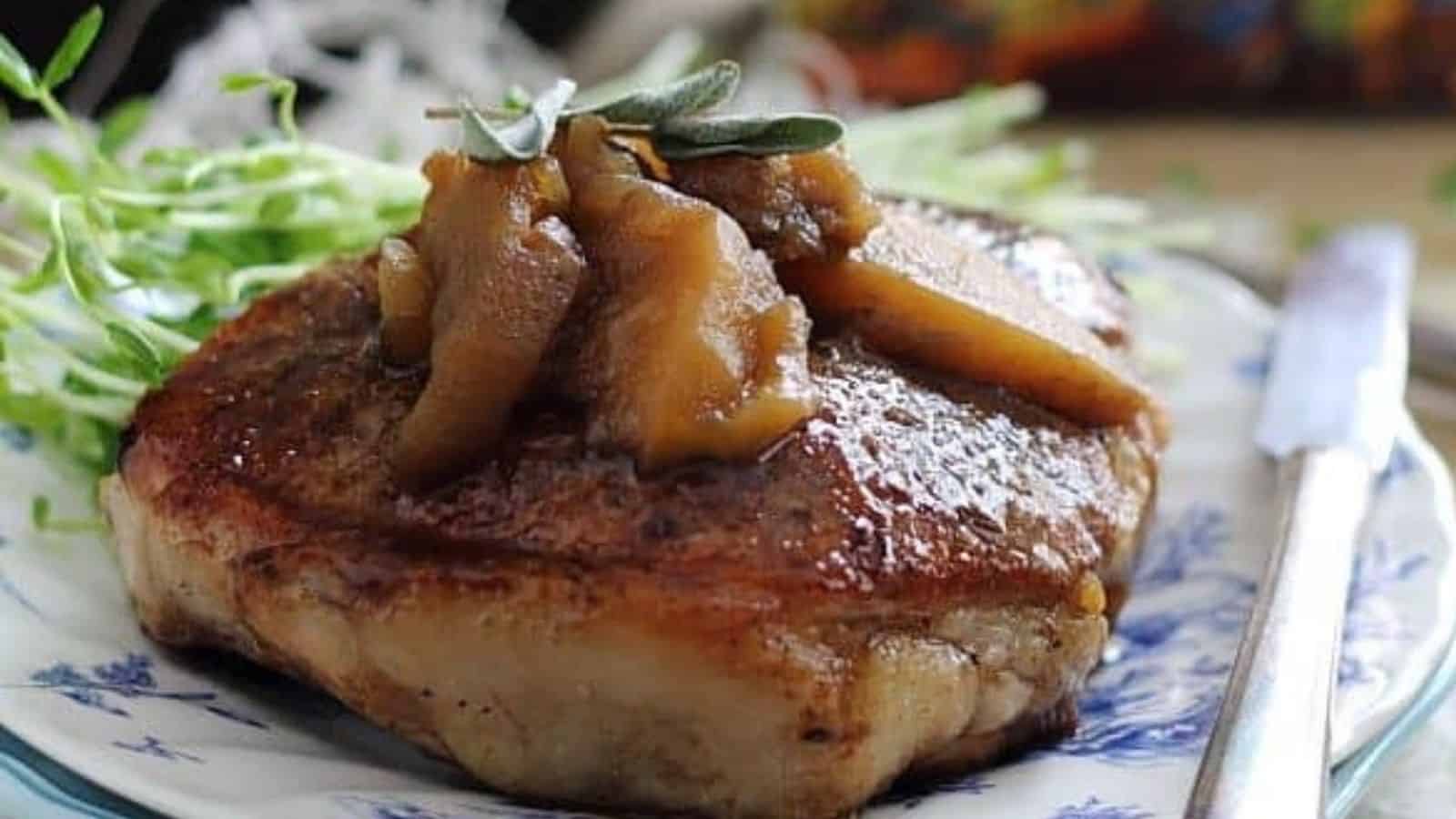 Close-up image of pumpkin tea glazed pork chops and apples on a plate.