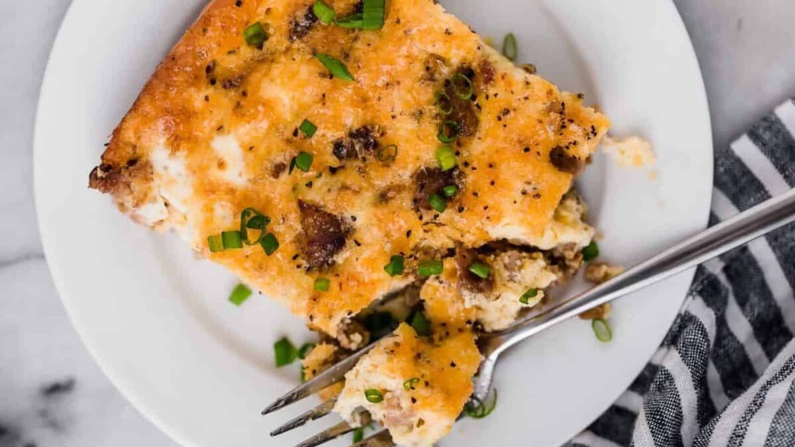 Sausage breakfast casserole on a plate with a fork.