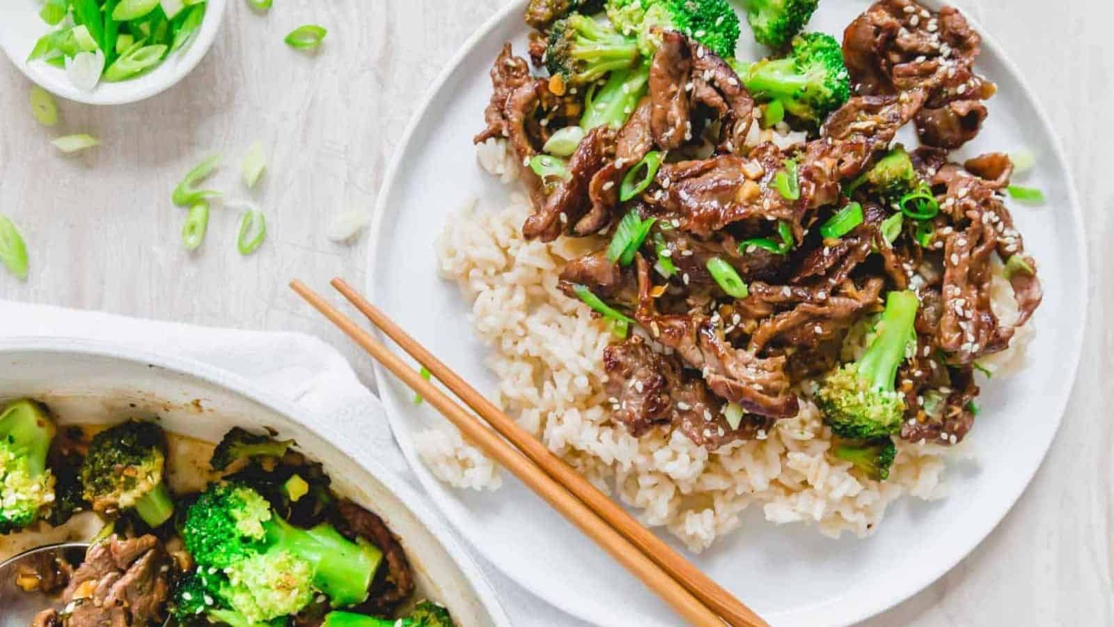 Beef and broccoli stir fry served with white rice on a white plate.