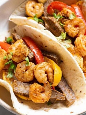 Shrimp and steak fajitas with peppers and onions.
