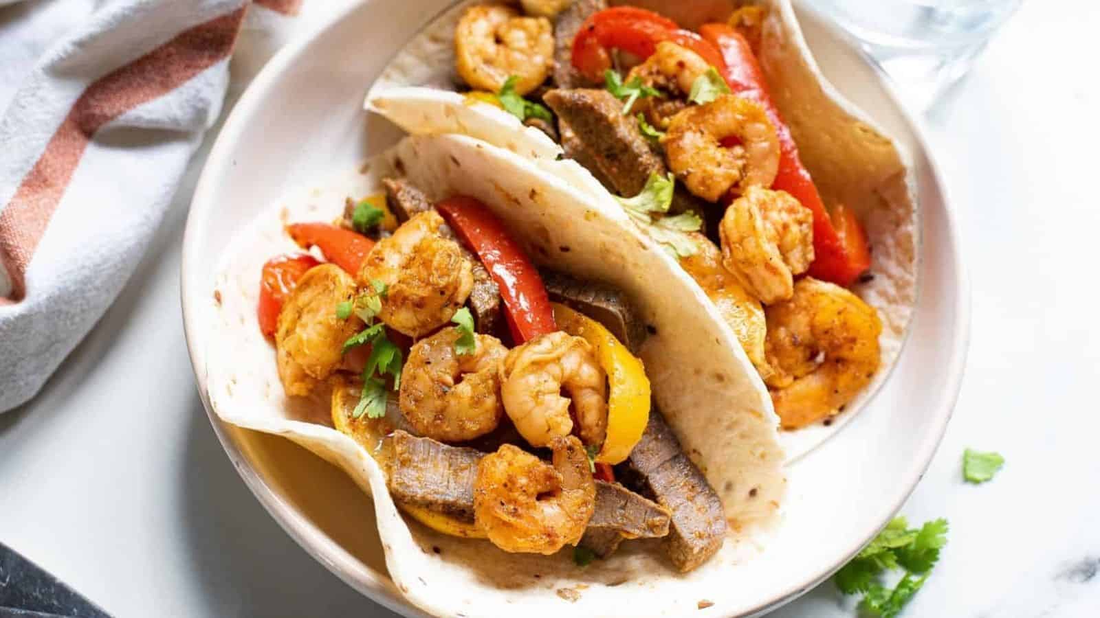 Shrimp and steak fajitas with peppers and onions.