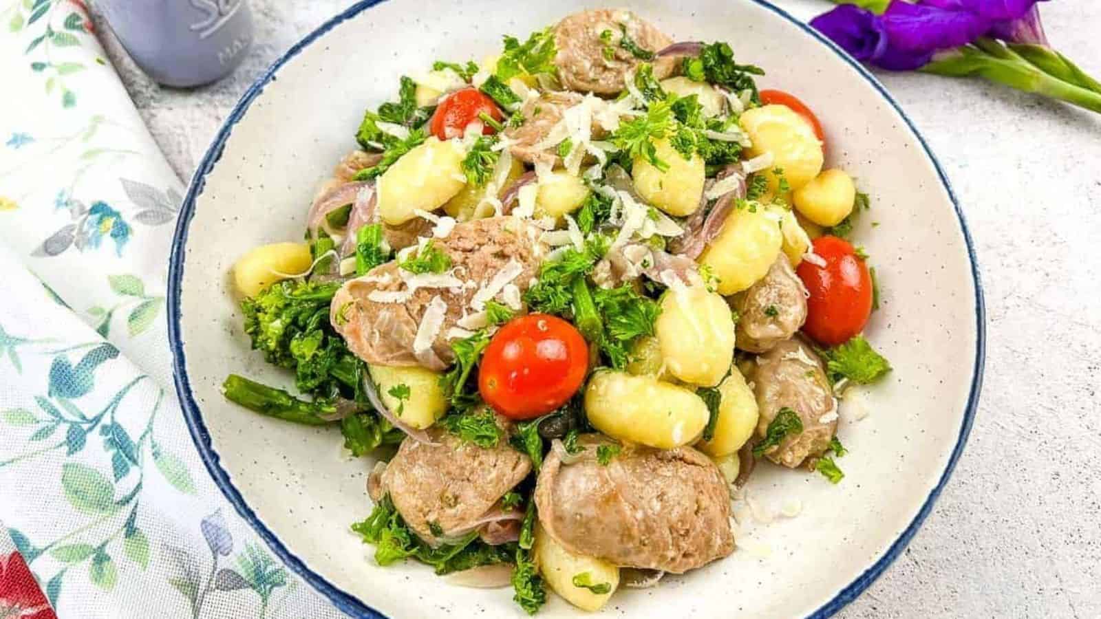 A bowl of skillet gnocchi with sausage and broccoli rabe.