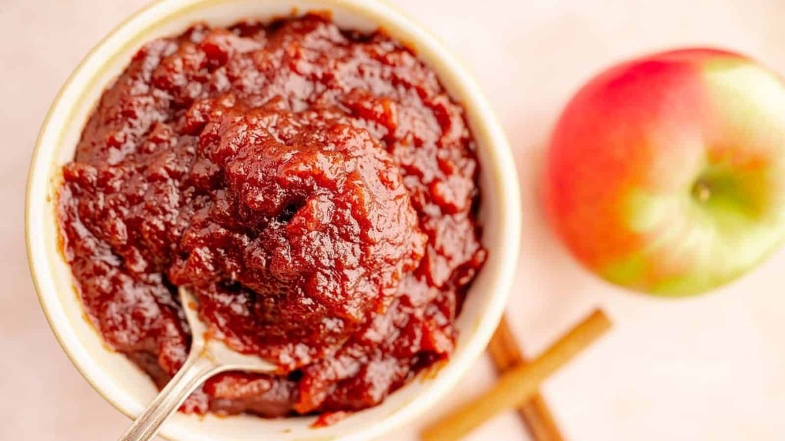 Overhead image of slow cooker apple butter with a spoon in a bowl.