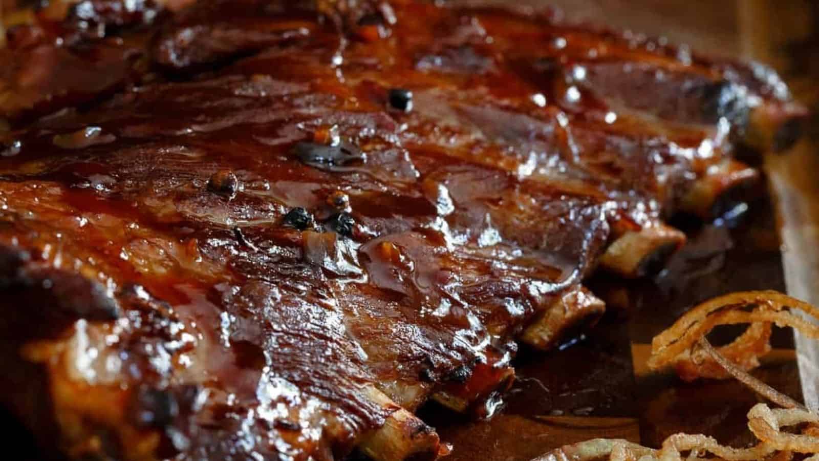 Close-up image of sticky maple apple ribs with shoestring fried apples.