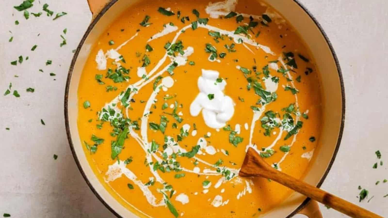 Two bowls of sweet potato and red pepper soup with sour cream and parsley.