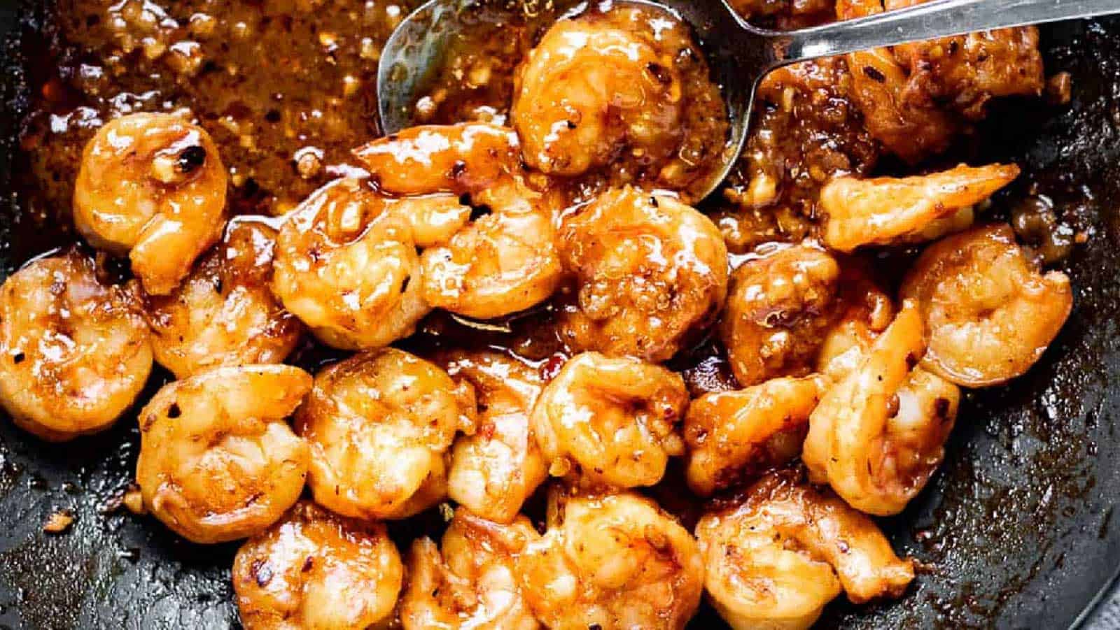 Low angle shot of szechuan shrimp in a wok.