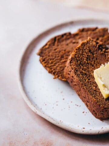 A plate with two slices of Teff Flour Pumpkin Bread.